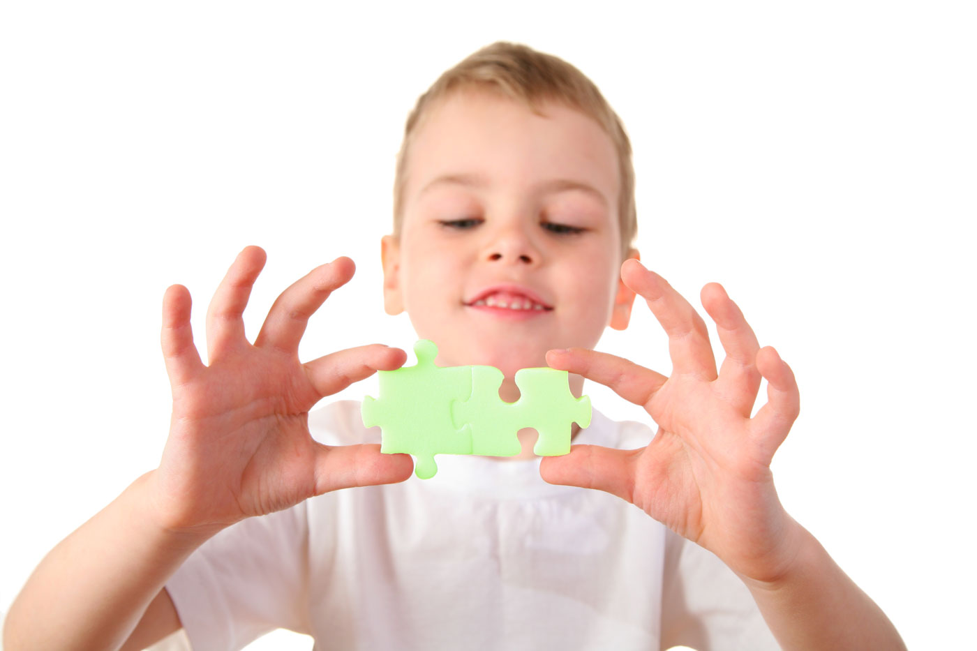 Stock image of young boy holding jigsaw piece