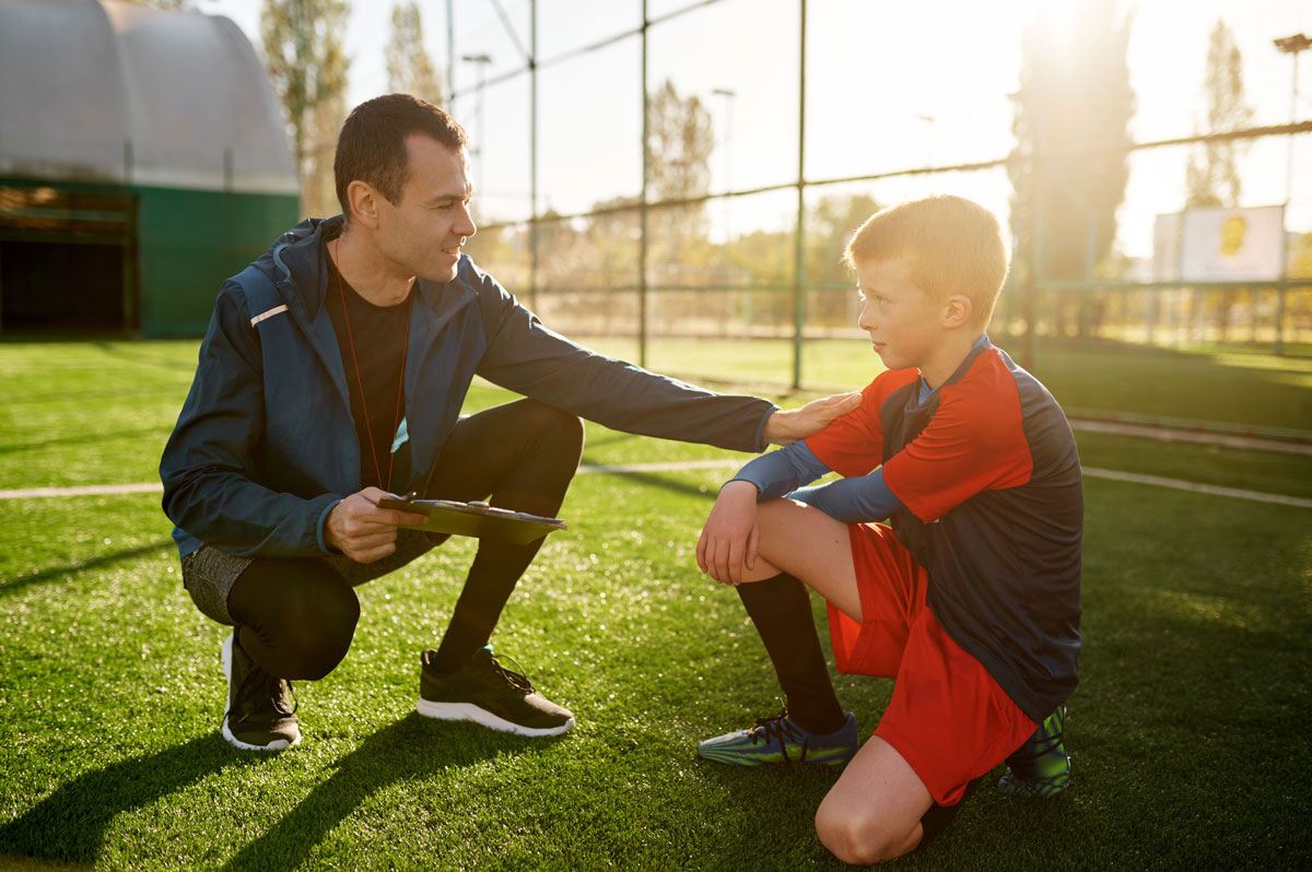 Stock image of a PE teacher and pupil talking